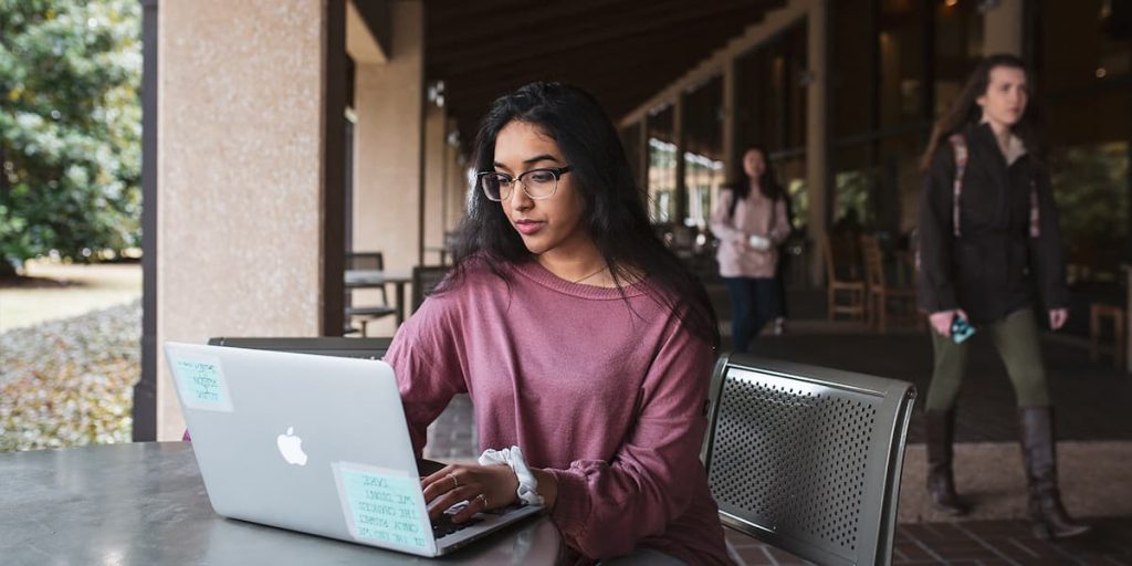 UT Dallas Student with laptop outside of Student Union